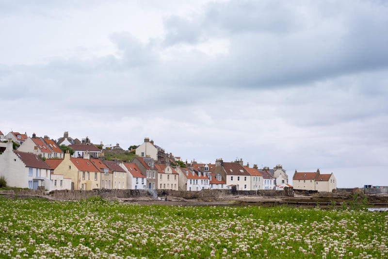 Row of quaint fisherman cottages along the waterfront overlooking the beach and ocean at low tide Pittenweem, Scotland