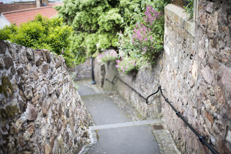 Winding footpath between natural stone walls in Pittenweem, Scotland, a quaint fishing village on the Fife Coast