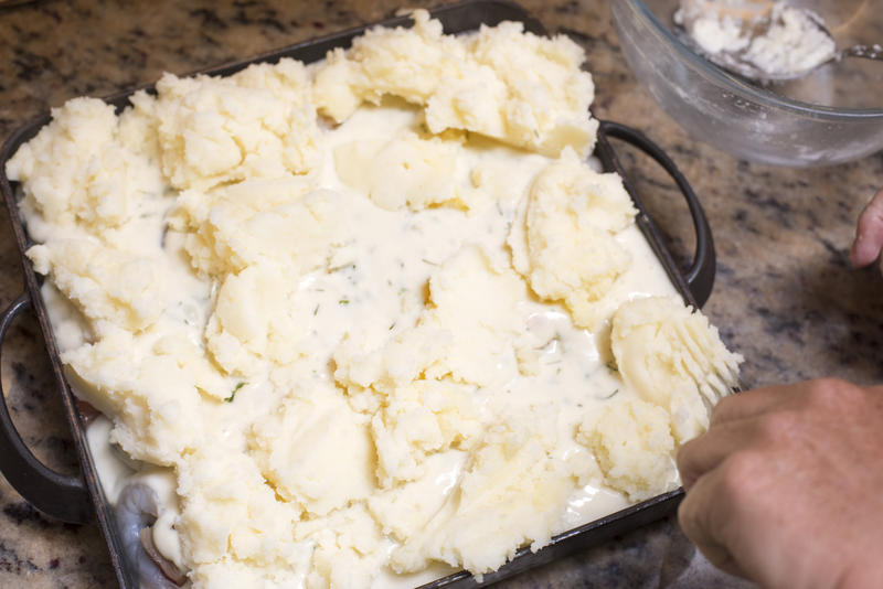 Thick creamy mashed potato pie topping viewed high angle on a granite kitchen counter