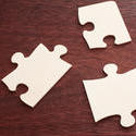 12737   Three blank puzzle pieces over brown table