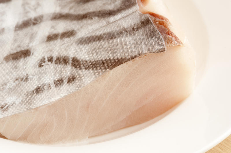 Close up texture of a raw mackerel steak with the striped skin uppermost for a healthy seafood dinner rich in omega-3 fatty acids