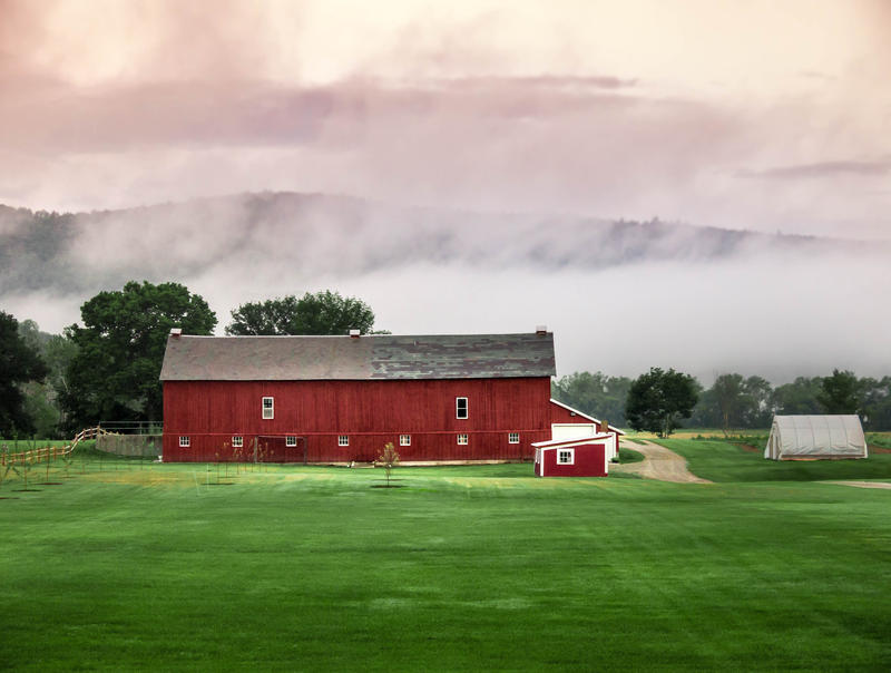 <p>Red Barn, fog, clouds and green grass rural Vermont.</p>