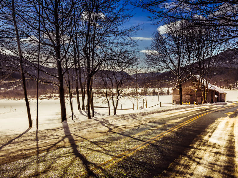 <p>Early morning road and barn in Winter with trees and snow.</p>
