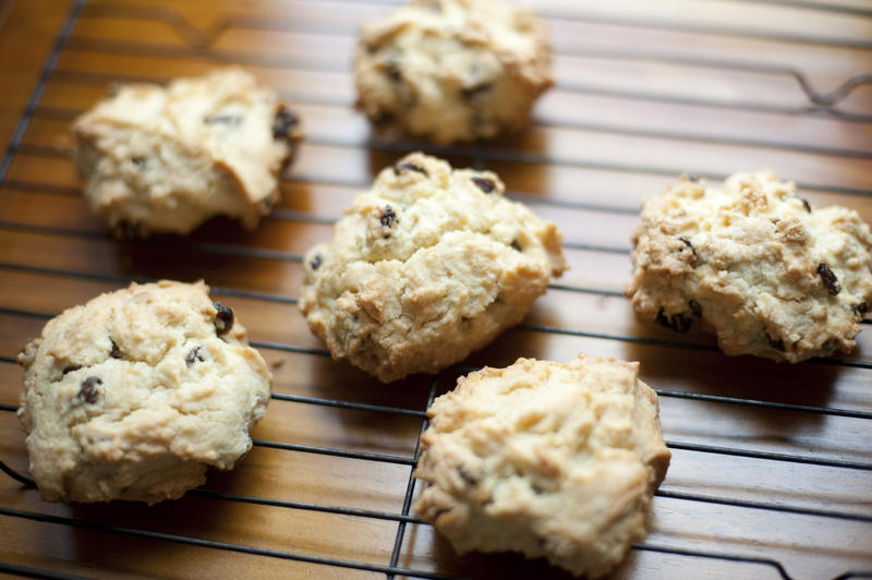 Delicious freshly baked homemade sweet rock cake cookies filled with chopped dates and walnuts on baking tray over wooden table