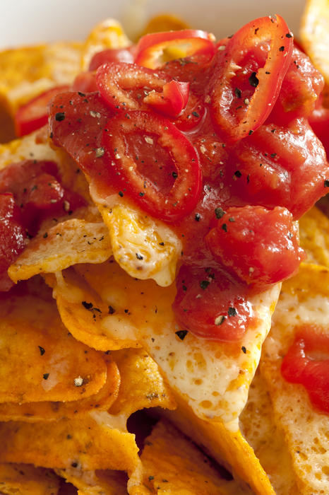 Hot spicy red chili pepper salza on corn tortillas or nachos with melted cheese for a tasty Mexican snack