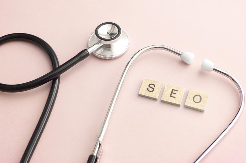 SEO Expertise concept with little blocks and medical stethoscope over pink background