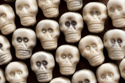 12786   Background of white plastic toy skulls