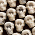 12786   Background of white plastic toy skulls