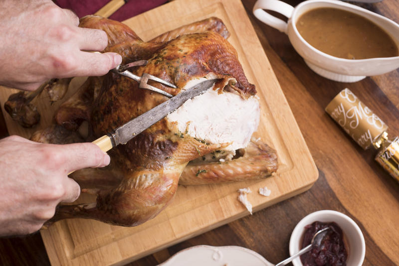 carving meat from a thanksgiving or celebration dinner roast turkey