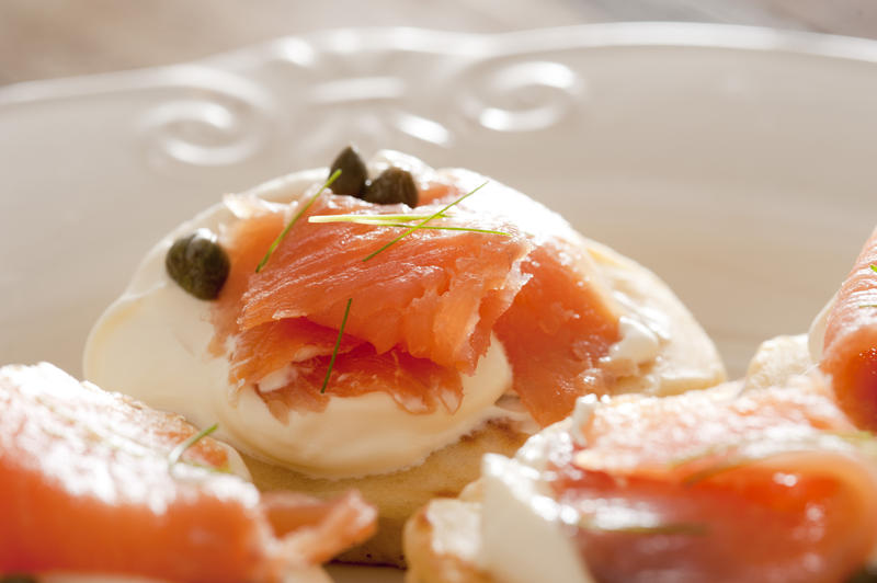 Delicious snacks or appetizers of fresh smoked salmon and capers on cream cheese served on sliced bread