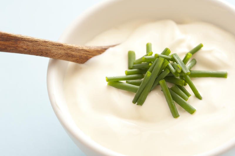 Small bowl of thick and creamy soup with wooden spoon and topped with chopped herbs