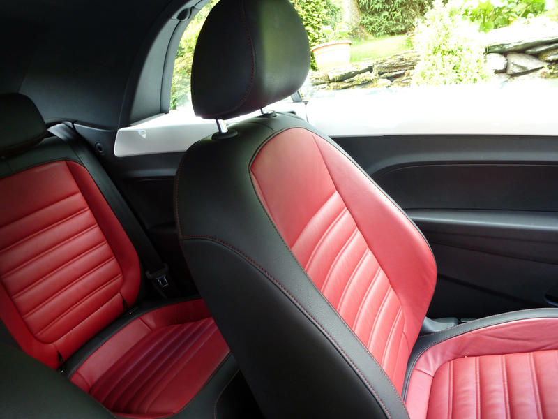 Colorful red and black leather sports seats in a modern car viewed through an open passenger window