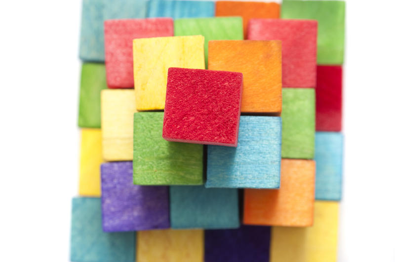 High Angle View of Stack of Colorful Wooden Toy Blocks in Pyramid Shape in Studio with White Background and Copy Space