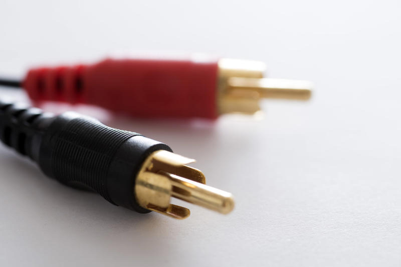Black and red stereo phono plugs with gold metal connector close-up on white background
