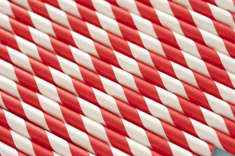 Closely packed red and white drinking straws or poles as full frame background with copy space