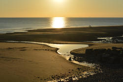 17019   Sunset on the beach showing sea.