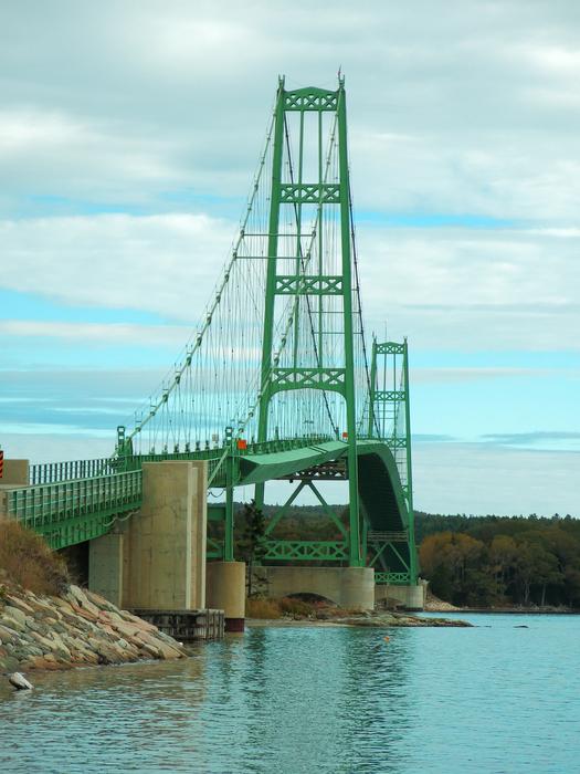 <p>Green suspension bridge connecting one small island to the Maine land on the coast of Maine. </p>