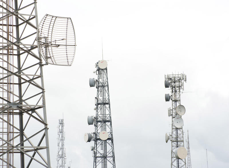 Telecommunication masts and towers against clouds or fog