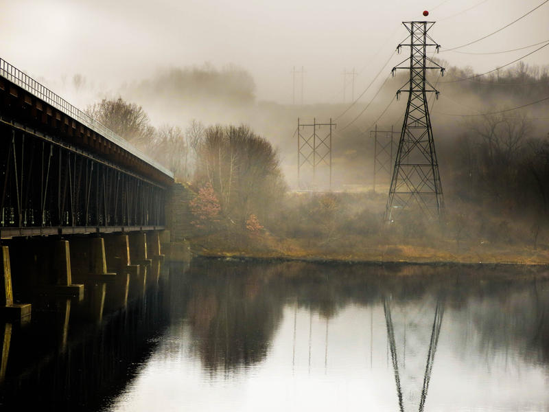 <p>Train tressel over the Hudson River with distant fog and power lines.</p>

