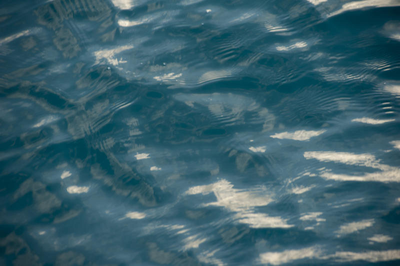 Rippling water abstract background texture with sunlight reflections in a full frame view