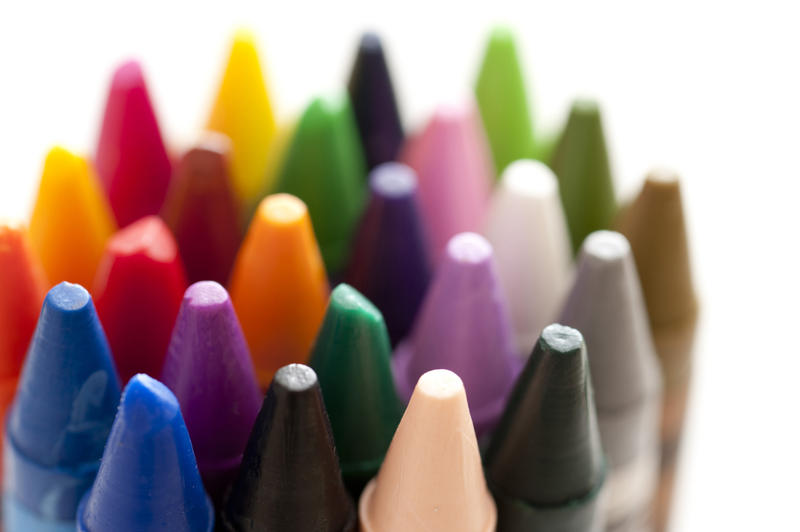 Bundle of colorful wax crayons with a close up shallow DOF view of the points over white in an educational and creativity concept