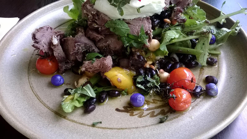 a warm beef salad with wild berries and garden salad leaves
