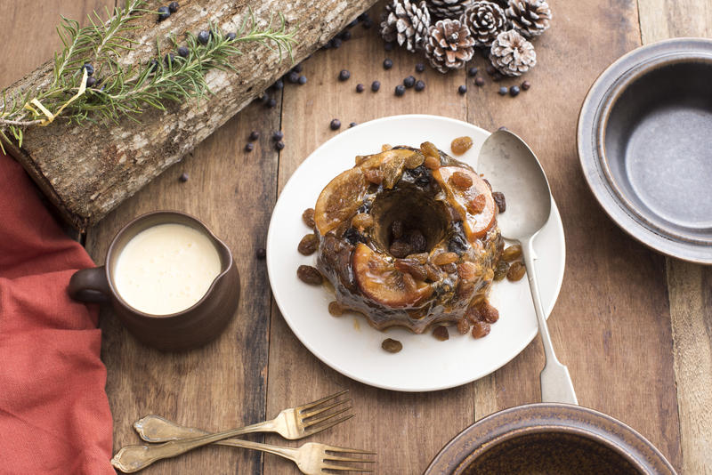 Pudding dessert on plate against wooden table among Christmas decoration