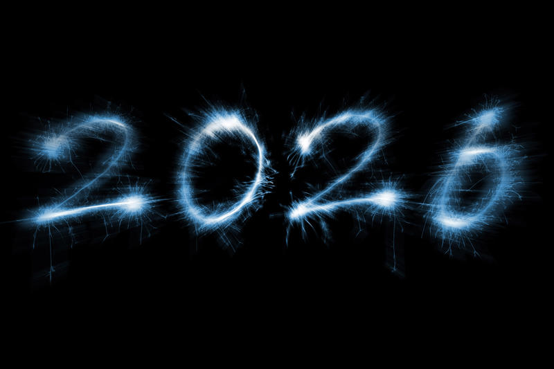 Numbers for New Year 2026 bursting out from a black background with bright ice blue sparks