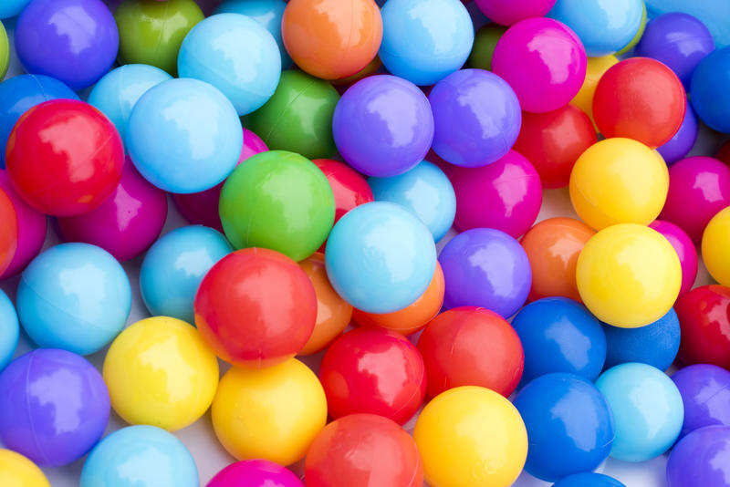 A close up of multicoloured plastic balls in a ball pit.