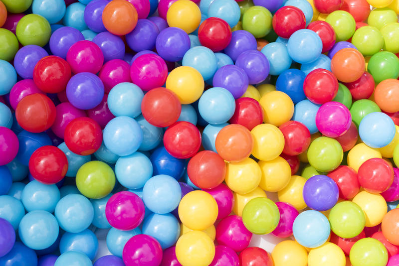 Full frame background of brightly colored plastic balls heaped in a ball pool at an amusement park or fairground