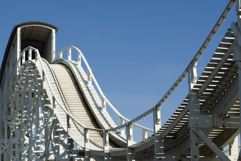 Steep hill and tunnel on a Big Dipper rollercoaster in a close up view on the track against a sunny blue sky