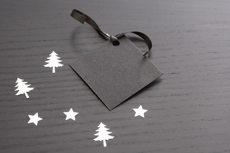 christmas gift tag with space for text surrounded by stars and tree shapes in silver