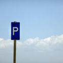 17821   Blue parking sign in front of a cloudy sky
