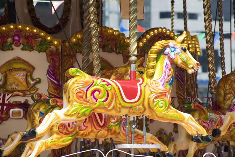 Decorative brightly colored horse on a carousel or merry-go-round in close up at an amusement park or fairground