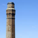 17818   Old brick industrial chimney top against blue sky