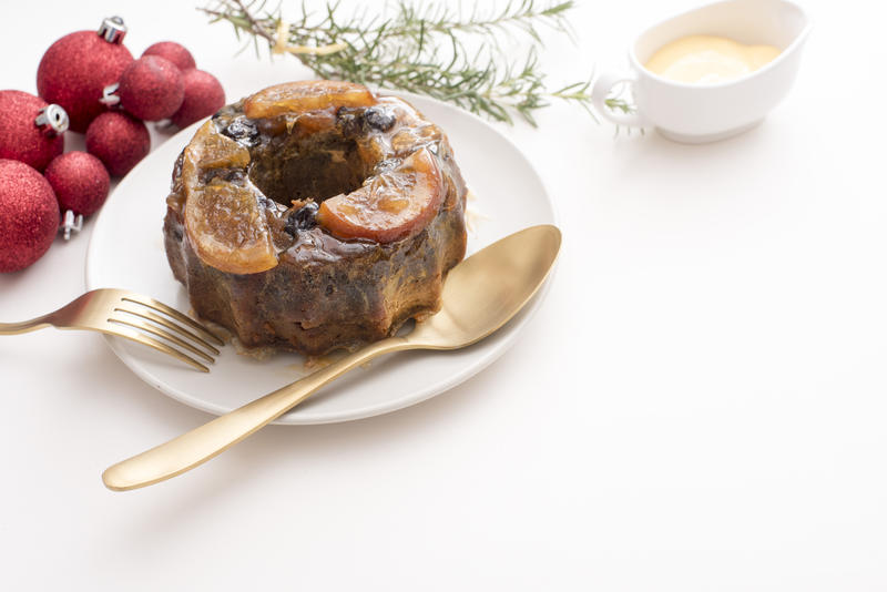 a modern christmas table setting with brandy fruit pudding and space for text to be added