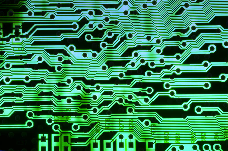 A close up of green wiring on an electrical circuit board.