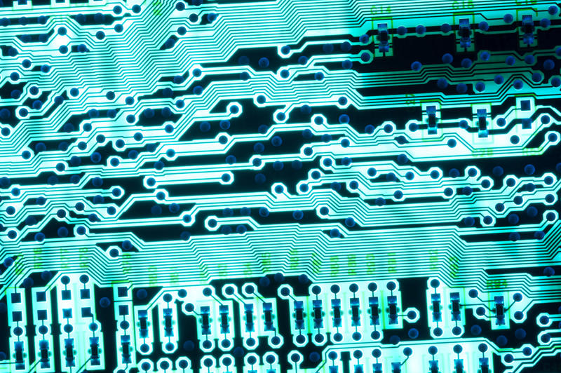 Close up electronic background of a cyan colored printed circuit in a full frame view conceptual of technology