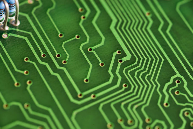 closeup on the pattern of tracks on a green coloured electronic circuit