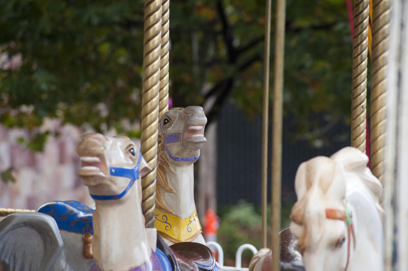 A close up of carousel horses on amusement park ride with no people.