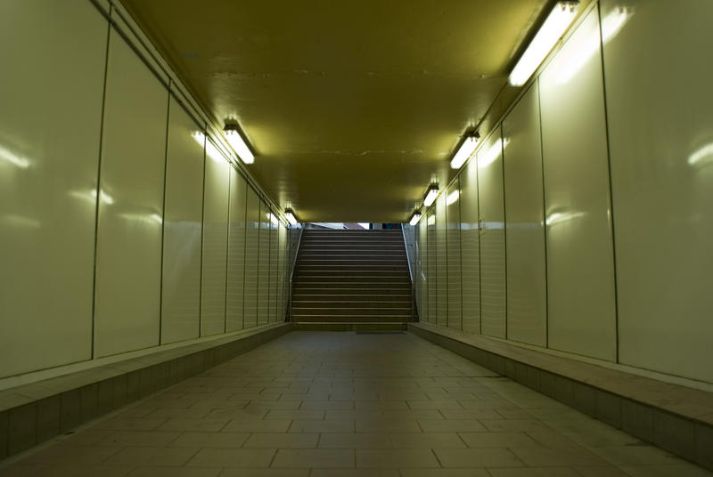 Empty illuminated underground subway tunnel with steps at the end in a concept of the travel ban during the coronavirus pandemic