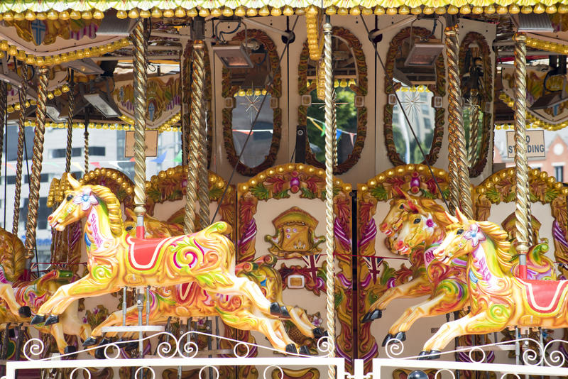 Colourful yellow horses on a fairground carousel or merry-go-round in a close up view