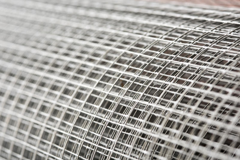 Close up on a large roll of steel fencing wire mesh with selective focus and copy space in a full frame view