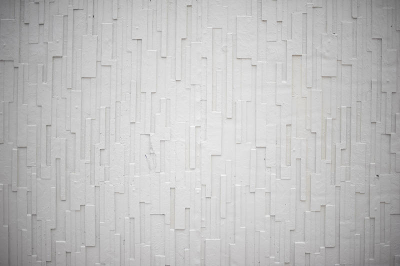 An isolated shot of a white, formed concrete wall with vertical pattern.
