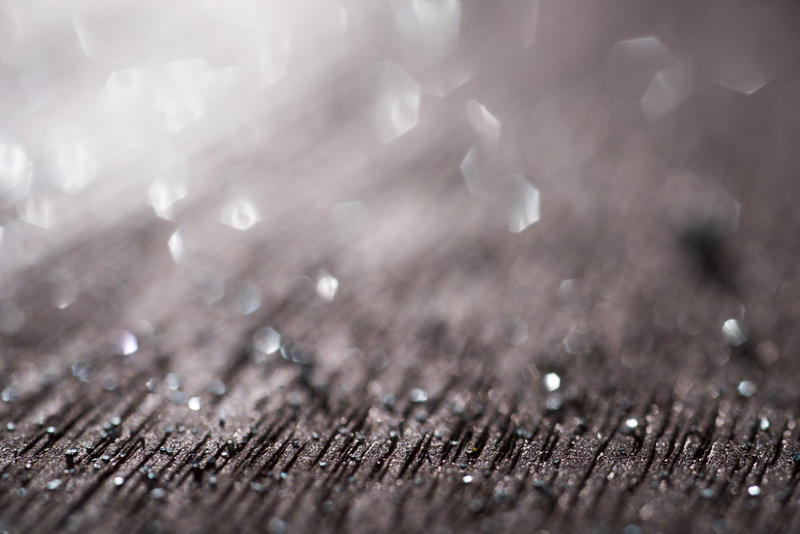 Close-up and selective focus of brown surface covered with furrows and with glitter sparkles and bokeh effect on blurred background
