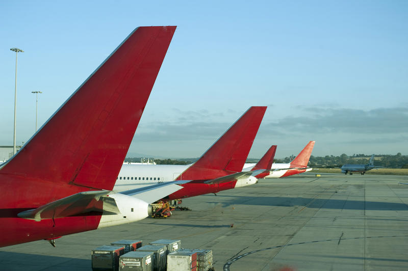 Line of aircraft parked up on the apron at an airport in a concept of grounded aircraft during the coronavirus pandemic due to the travel ban