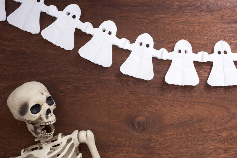 a halloween backdrop with ghosts and a funny skeleton figure