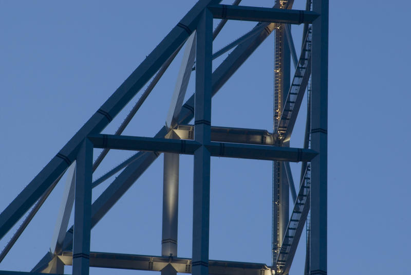 Detail of a the framework of an open sided high-rise spire on top of a building against a blue sky