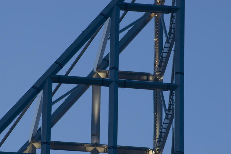 Detail of a the framework of an open sided high-rise spire on top of a building against a blue sky