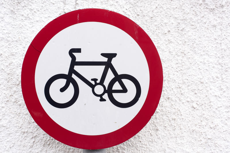 No Cycling road sign in close-up on white wall background with copy space